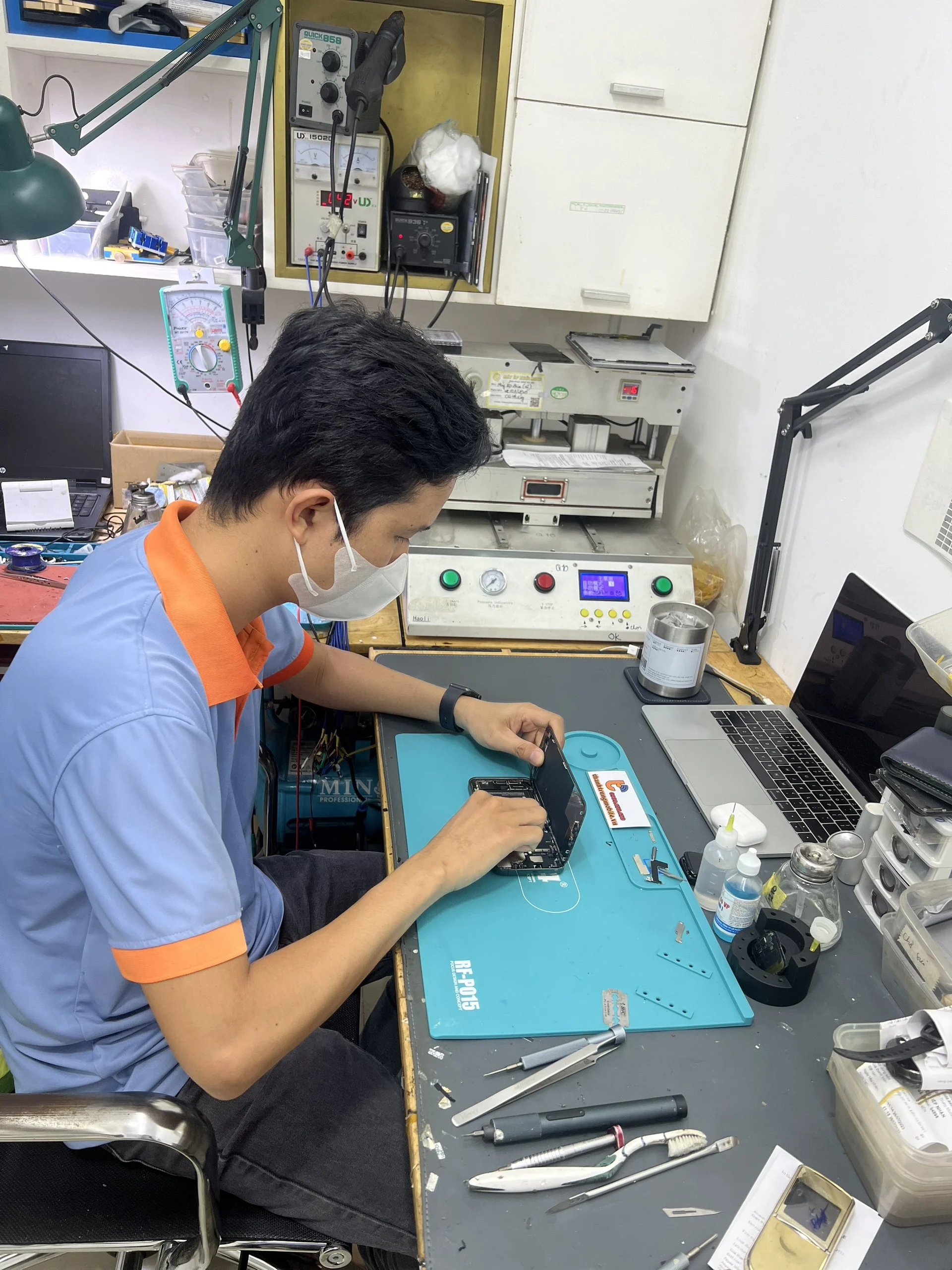 ky-thuat-vien-dang-thuc-hien-thay-pin-iphone-cho-khach-hang